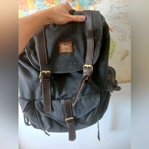 2 cool backpacks one is grey with leather straps and the other brown